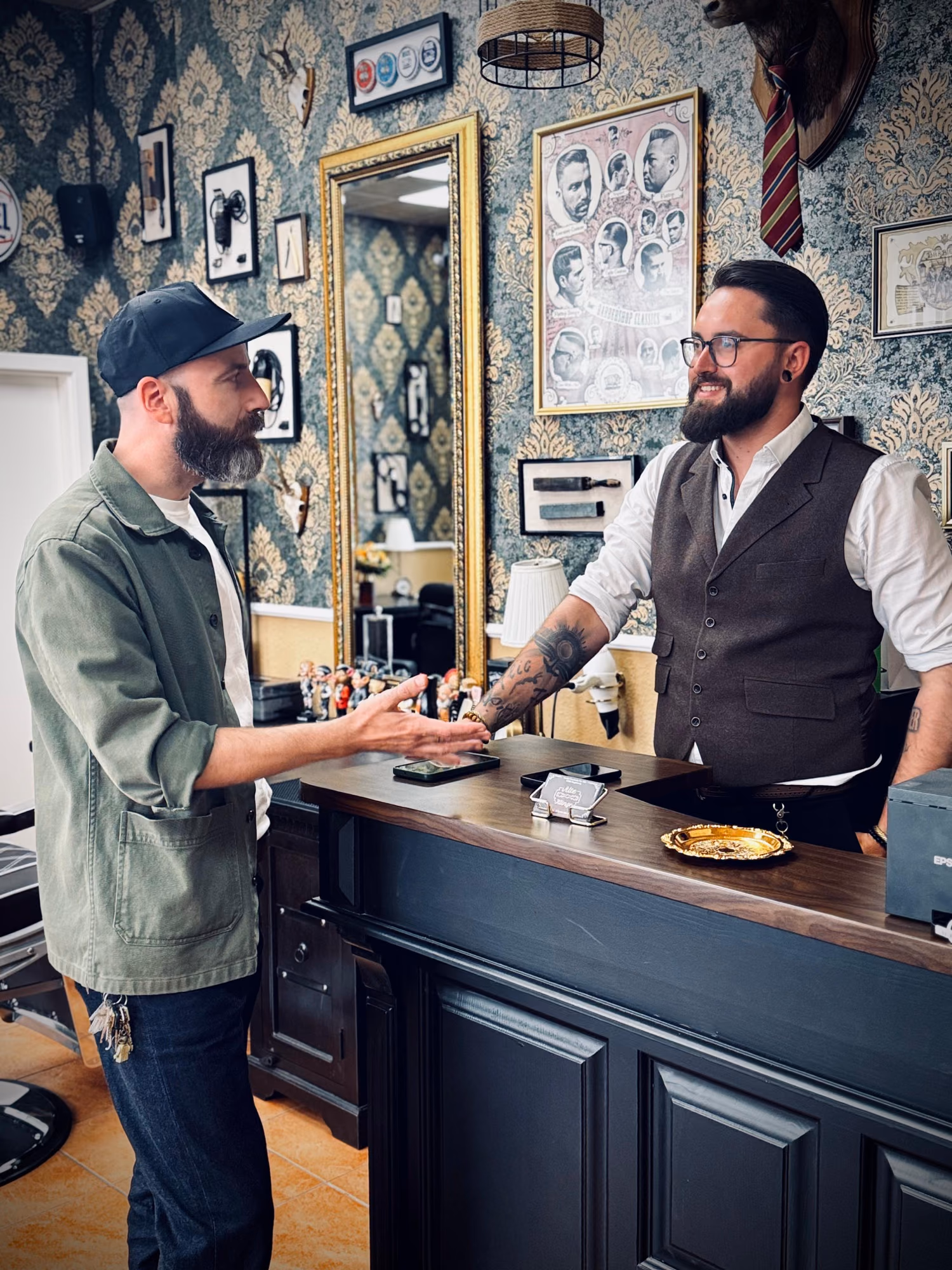 Daniel Jung berät einen Kunden am Tresen des Barbershops