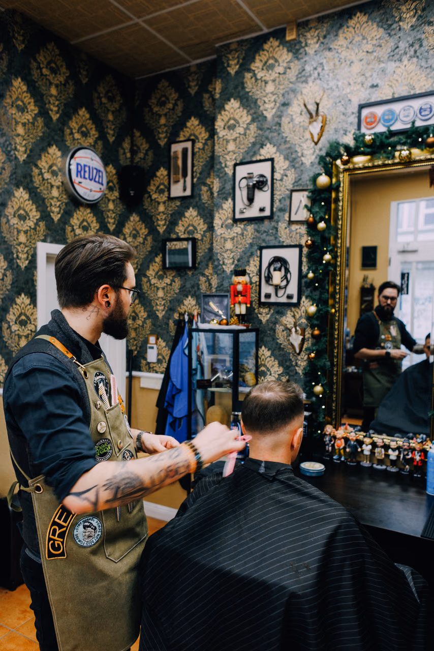 Haarschnitt im Salon, gespiegelt im Goldrahmen
